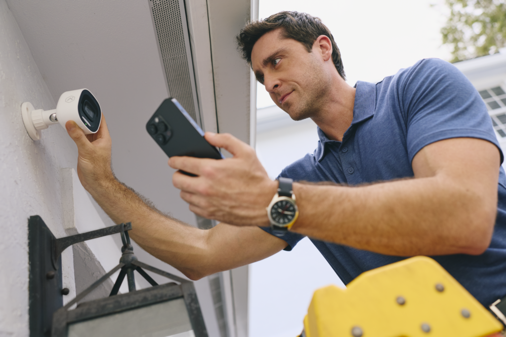 Close-up of a professional technician replacing old security hardware with a modern system setup.